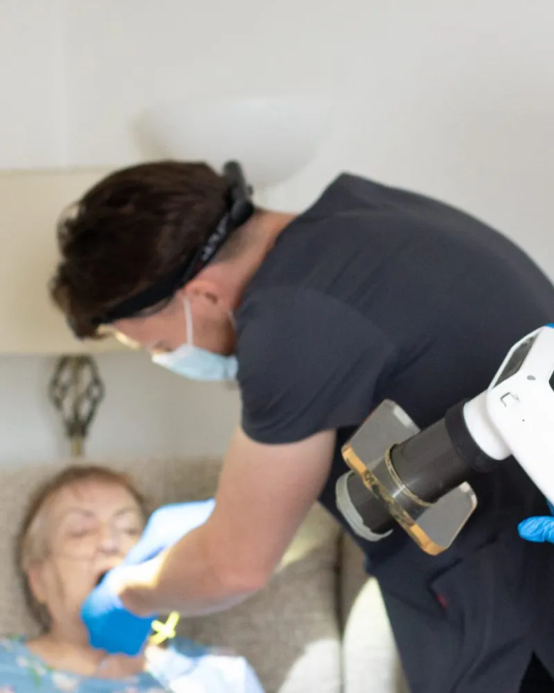 A dental nurse scanning a patient's dentures at home